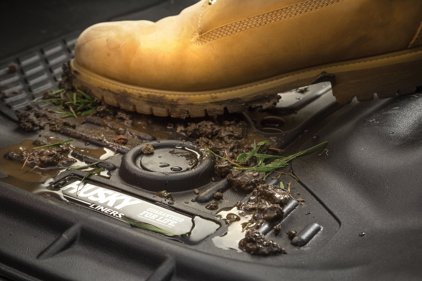 HUSKY LINERS X-ACT AXS mud and dirt-resistant truck bed liner for Dodge Ram 1500 Crew Cab, showing textured black surface.